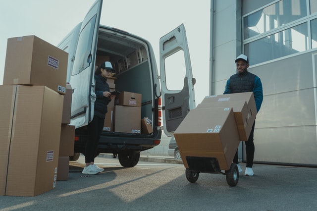 a man and woman delivering boxes telling amazon account management services